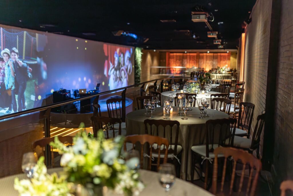 Beautifully decorated restaurant interiors with ambient lighting and event projections on the wall.